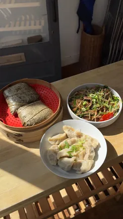 Group of friends enjoying a dim sum cooking class at School of Wok in London, making dumplings together.