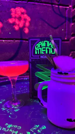 Colorful cocktails and retro arcade games at NQ64 bar in Leeds, perfect for a fun night out with friends.