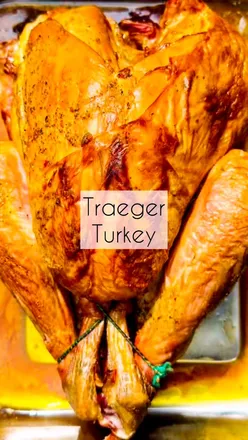 Juicy roast turkey cooked on a Traeger grill, seasoned with garlic butter, perfect for sandwiches and stock.