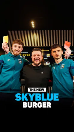 Two stacked burgers in a heated competition, featuring the exclusive Sky Blue Burger available on Uber Eats in Coventry.
