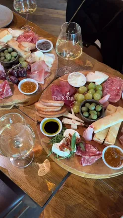 A charcuterie board with wine, enjoyed with friends at Veeno, showcasing delicious food and drinks.