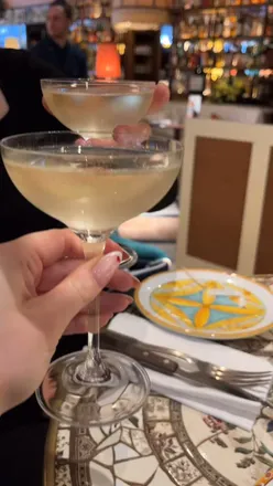 Group of friends toasting with champagne glasses at Gloria Trattoria, celebrating the bank holiday weekend.