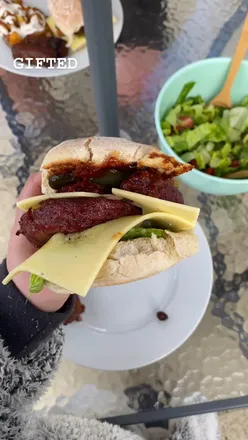 Juicy Yeo Valley organic steak burgers stacked with cheese, lettuce, and chutney for a summer BBQ feast.