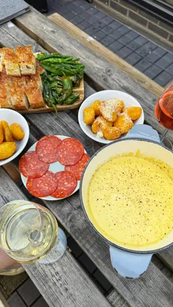 Cheese fondue bottomless brunch at The Mews Manchester with Fontina cheese, meats, breads, veggies, and bottomless wine.