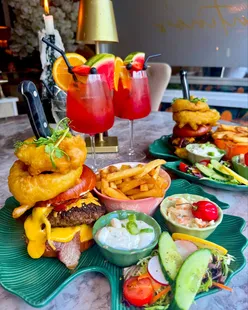 Tarantinos Sunderland burger loaded with toppings, featuring a standout onion ring, in a family-friendly restaurant setting.