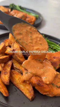 Creamy paprika chicken with garlic sauce and crispy potato wedges, a delicious dinner favorite.
