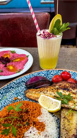 Hidden outdoor terrace on Gloucester Road, Bristol with views of blue skies, trees, and church. Enjoy Lebanese food, juices, chicken, lamb, and seafood at Lona Grillhouse & Juicebar.