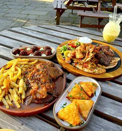 Outdoor dining at Mythos Greek restaurant in Chapel Allerton, Leeds, featuring Keftedes, Spanakopita, Ox Cheek Stifado, and Galaktoboureko.