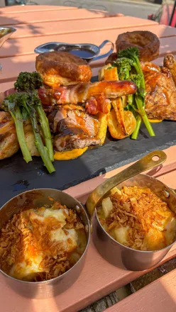 Massive sharing roast platter at Courts Cardiff's outdoor Laurent-Perrier terrace, featuring gluten-free fried chicken and sticky toffee pudding.