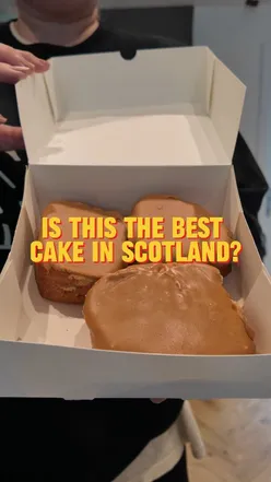 Fisher & Donaldson fudge doughnut with creamy custard and sweet fudge icing, evoking nostalgia and warmth in Dundee.