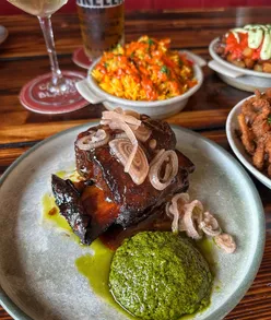 Tapas dishes at Campo Blanco: hummus with seeds, fried aubergine, tenderstem broccoli, flat iron steak, beef short rib, pork chop, croquetas de jamón, fried calamari, sea bream, patatas bravas, saffron rice.