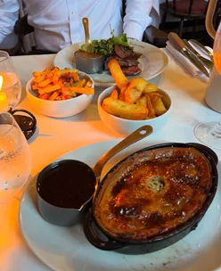 Classic British meal at Dog and Collar Pub: chicken tarragon pie, triple cooked chips, steak frites, Guinness sticky toffee pudding.