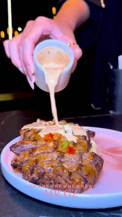 Mr Gz Birmingham: steak with peppercorn sauce, samosa chaat, nachos, lamb chops, Mrs G’s Combo Box with smash burger, chicken tenders, fries, lamb kebabish, mac & cheese, dessert, desi tea; cozy night setting.