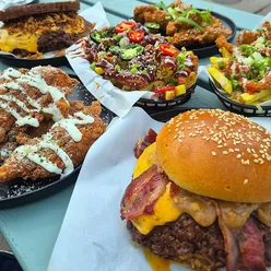 Ground & Pound burger feast: Falcon burger with peanut butter, bacon, jam, Beef Curtains burger, garlic parmesan chicken strips, satay chicken strips, loaded fries.