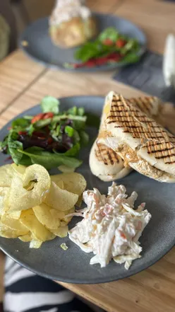 Cozy Cardiff café with friendly vibes, resident pup Ted, chicken tikka panini, tuna jacket potato, bacon sandwich, and cake selection.