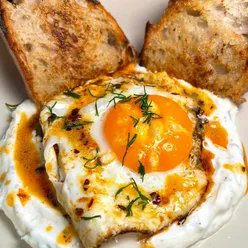 Fried Turkish-style eggs with chili butter on San Francisco sourdough, served with Greek yogurt, garlic, dill, lemon, salt, and pepper.