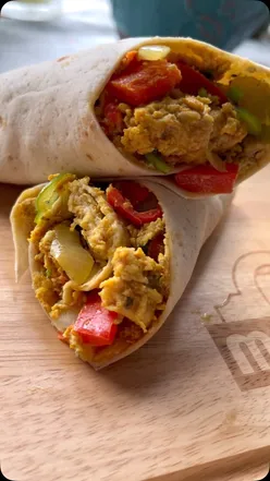 Masala egg wrap with cumin, onion, garlic, peppers, tomatoes, turmeric, garam masala, and fresh coriander in low-carb wrap.