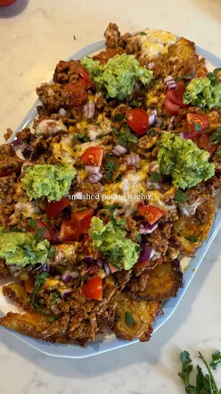 Smashed potato nachos topped with avocado, perfect for dinner or sharing as a snack, hearty and full of nacho flavors.