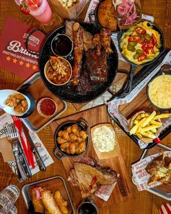 Hickory's Smokehouse Sheffield platter with Texas brisket, ribs, pulled pork, cheesy fries, cornbread, and kid-friendly options.