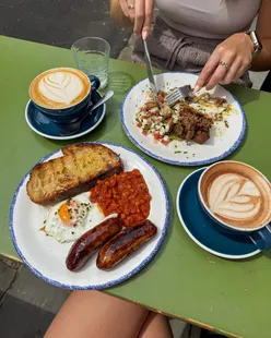 Al fresco brunch at White Cloth Hall, Leeds: Lupton's sausage, egg, beans on sourdough, Salma's birria hash, Morty's pizza bread sandwich, mocha, hazelnut latte.