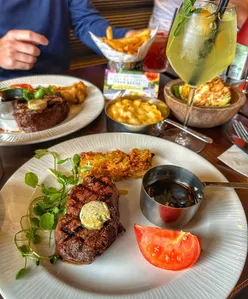 Steak with side, iceberg wedge, sauce, and onion loaf at Miller and Carter, paired with a cocktail, available Mon-Wed for £22.50.