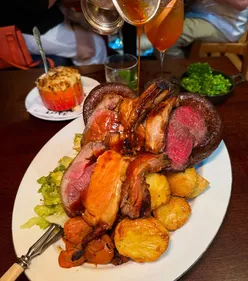 Sunday roast at Blacklock Chops Manchester with beef, lamb, pork, trimmings, cauliflower cheese, and white chocolate cheesecake.