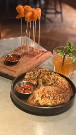 The Alchemist Eldon Square's theatrical cocktails, succulent Tempura Prawns with Vietnamese chilli dip, and Steak 'French Dip' Sandwich with truffle gravy.