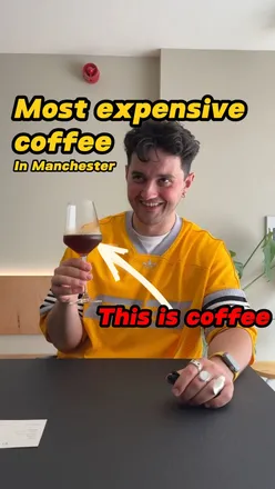 Expensive coffee at Salemoon Coffee in Manchester, featuring a £7.5 iced pour over in a wine glass, cozy atmosphere.