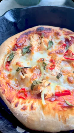 Homemade chicken BBQ pizza in a cast iron pan with leftover roast chicken, veggies, mozzarella, and Sauce Shop BBQ sauce.