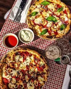 Wood-fired pizza at Olibonny Pizza, Bourton-on-the-Water, Cotswolds, by the river, perfect for pizza lovers and foodies.