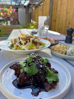 Hidden Oxford pub beer garden with chicken Caesar salad, pork belly bites, spinach feta dip, taramasalata, and Hugo spritz.