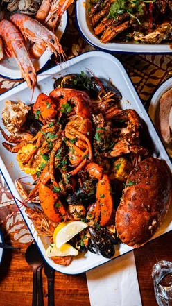 Whole lobster tail and seafood boil with crab, prawns, mussels, potatoes, corn, and sausage at The Gothic Crab, Kemptown.