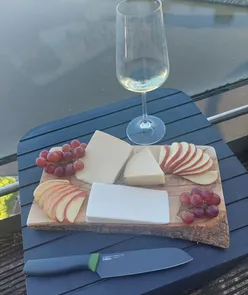 Assorted cheeseboard with various cheeses on a sunny day, perfect for a relaxing evening.