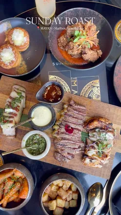Boujee Sunday roast at Mayan Restaurant, featuring 28-day aged sirloin, crispy pork belly, and white chocolate mash in Yorkshire pudding.
