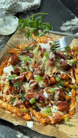 BBQ chicken and bacon loaded fries with crispy homemade fries, melty cheese, ranch drizzle, and crunchy bacon bits.