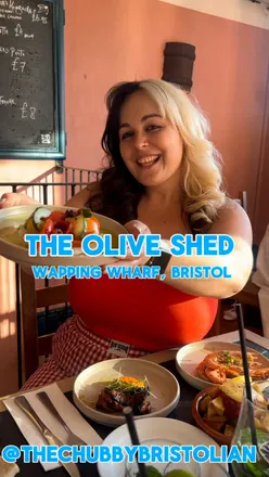 Gluten-free small plates at Olive Shed Bristol: patatas bravas, zaatar chicken, gambas in garlic oil, tomato salad with feta, waterfront view.