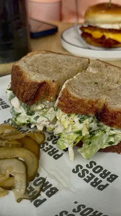 Chicken Caesar sandwich with creamy filling and citrus zest on fresh bread at Press Bros Coffee.