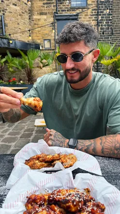 Unlimited chicken wings at Saw Grinders Union in Sheffield, featuring 5 flavors like Korean Sticky and Sweet BBQ, with outdoor seating.