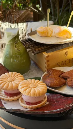 Contemporary Japanese Sunday brunch spread at Sachi London with steak, black cod, and dessert platter on rooftop.