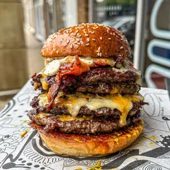 Exceptional beef burger with crispy bacon, cheeses, and toppings at Libertine Burger, Rugby location.