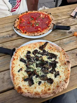 Delicious pizza enjoyed at Strandpaviljoen Zuid, with a stunning beach sunset in the background.