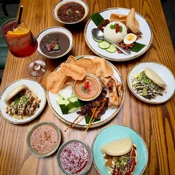 'Delicious sharing platter featuring satay skewers, prawn sambal, and bao buns at Kuala Lumpur Café, White Cloth Hall, Leeds.'