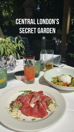 Al fresco dining at The Royal Horseguards Hotel's hidden garden with delicious dishes and cocktails by the Thames in London.