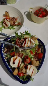 Fresh summer salad with mixed greens, cherry tomatoes, bacon, goat cheese, and balsamic glaze, perfect for any meal.