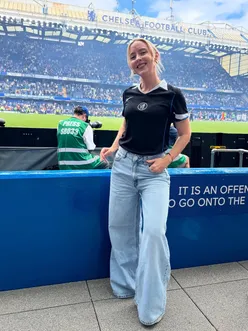 Chelsea fan showcasing the new third kit at Stamford Bridge, celebrating football culture and team spirit.