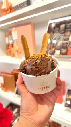 Indulgent Neuhaus chocolate mousse cups with toppings and a biscuit spoon, perfect for sharing or satisfying a sweet craving.