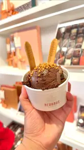 Indulgent Neuhaus chocolate mousse cups with toppings and a biscuit spoon, perfect for sharing or satisfying a sweet craving.