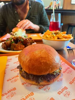 Couple enjoying butter and American burgers, crispy chicken, cheese fries, and cherryade at Burts in Heaton, Newcastle.