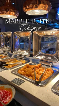 Delicious dishes at Marble Global Buffet in Glasgow, featuring sushi, pizza, and a dessert bar with a chocolate fountain.