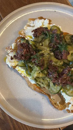 Delicious sourdough toast topped with ricotta, courgette, and figs, paired with a beautiful flat white at WSK Bakery.